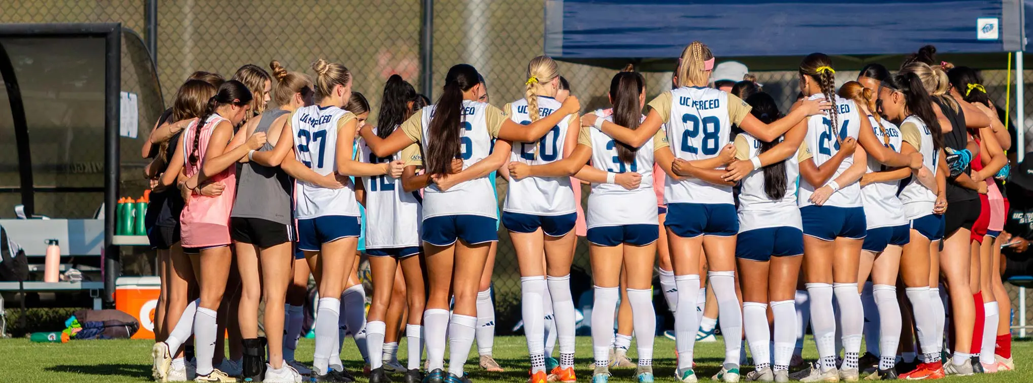 Women with arms around each other in a huddle